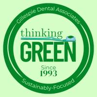 Round Green Badge with a toothbrush and the words "thinking green since 1993" in Asheville, NC